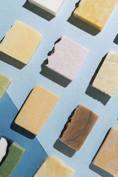 Flatlay of various natural hand-made soaps on blue, selective focus - Fotoğraf, Görsel