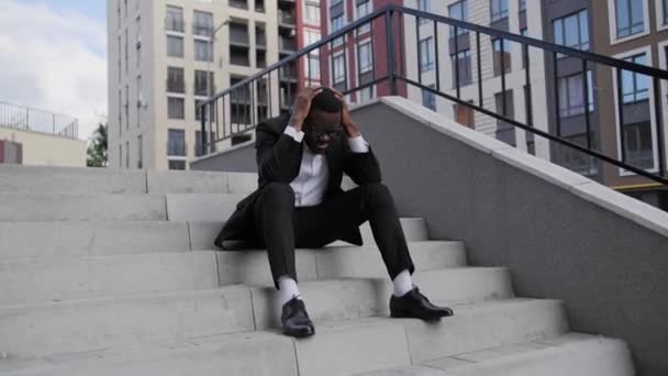 Афро-американець сидить на сходах і хвилюється про ситуацію в Нью-Йорку 2020 року, грабуючи і протестуючи Нью-Йорк через смерть Джорджа Флойда.. - Кадри, відео
