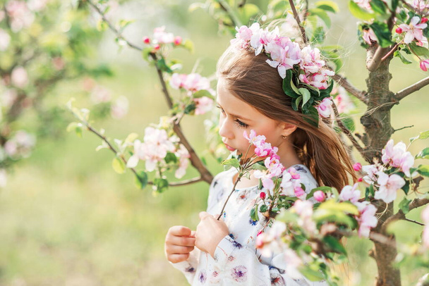 πορτρέτο ενός όμορφου κοριτσιού σε ανοιξιάτικο κήπο. Λουλούδια στα μαλλιά σου. - Φωτογραφία, εικόνα