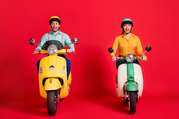 Portrait of his he her she nice attractive overjoyed crazy ecstatic cheerful cheery friendly couple riding moped traveling having fun isolated over bright vivid shine vibrant red color background - Photo, Image