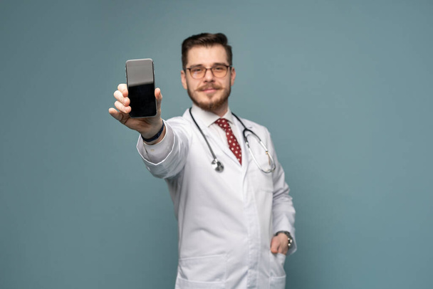A portrait of a medical doctor posing against gray background - Фото, зображення