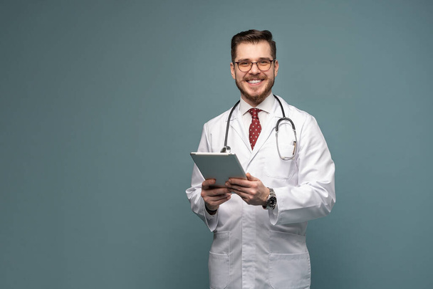 A portrait of a medical doctor posing against gray background - Foto, afbeelding