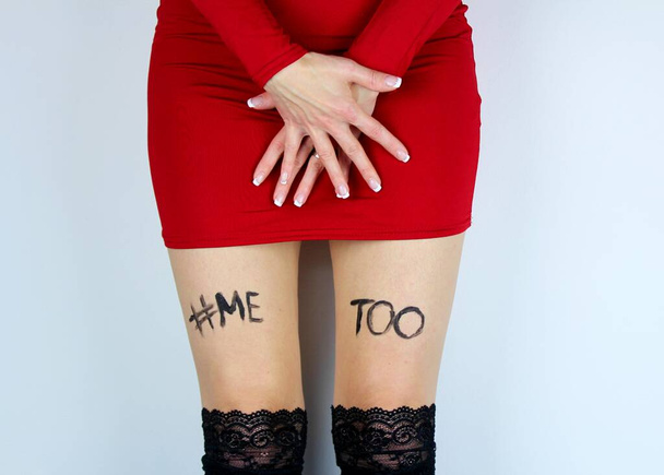Young woman in red dress with inscription on thighs.Woman in red dress with inscription me too . - Photo, image