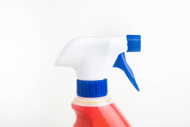Un primer plano de la parte superior de una botella de dispensador de plástico en aerosol líquido rojo, blanco y azul sobre un fondo blanco liso
. - Foto, imagen
