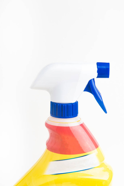 Eine Nahaufnahme des oberen Teils einer roten, weißen und blauen Sprühflasche aus Kunststoff auf schlichtem weißem Hintergrund. - Foto, Bild