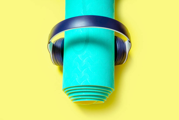 Flat Lay Sport and fitness equipment, headphones and mint yoga mat listen music on yellow background. Top view - Foto, Imagen