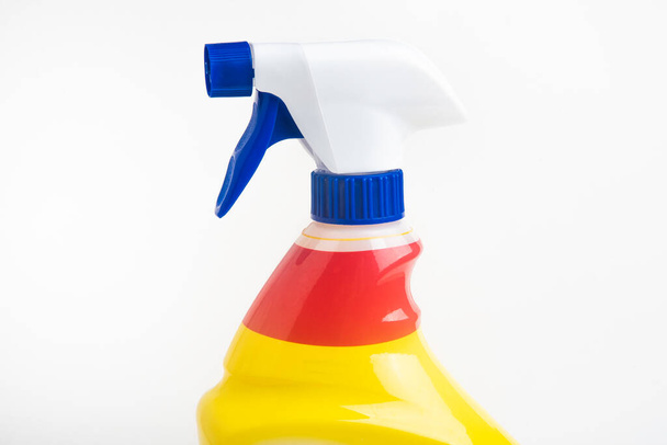 Um close-up da parte superior de um frasco distribuidor de plástico spray líquido vermelho, branco e azul definido em um fundo branco liso
. - Foto, Imagem