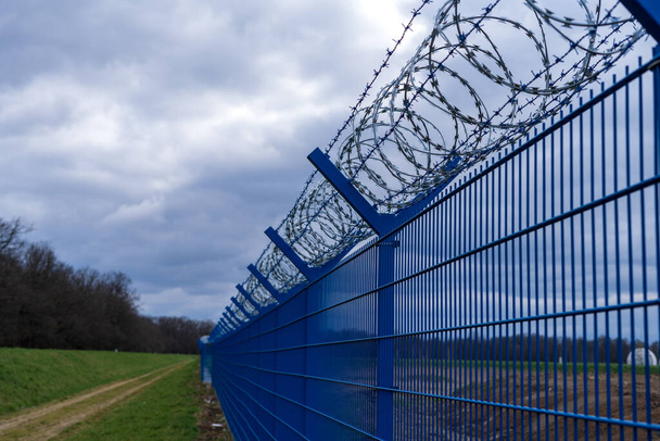 刑務所の鉄条網だ。刑務所のフェンスだ。犯罪に対する厳罰 - 写真・画像