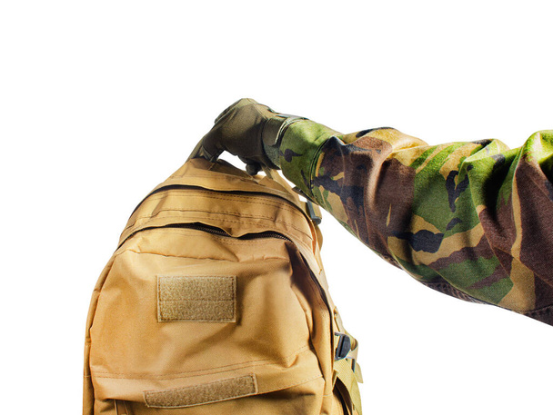 Primeira pessoa ver mão soldado isolado em luvas táticas e camisa camuflada segurando saco de oliva no fundo branco
. - Foto, Imagem