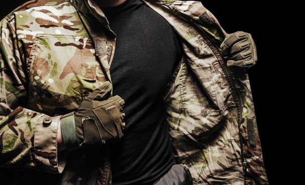 Foto de um soldado vestindo túnica de camuflagem multicâmara em fundo preto
. - Foto, Imagem