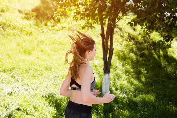 Young woman in sportswear running in summer park outdoors.  Healthy lifestyle concept. solo outdoor activities. Social Distancing  - Foto, imagen