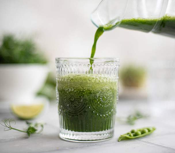 green vegetable smoothie made from microgreens, cucumbers, spinach and lime in a glass - Valokuva, kuva