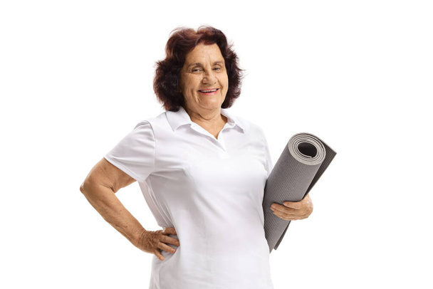 Elderly woman holding an exercise mat isolated on white background - Foto, Imagen