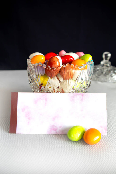 Σοκολατένια καραμέλα και εορταστική κάρτα σε λευκό απομονωμένο φόντο - Φωτογραφία, εικόνα