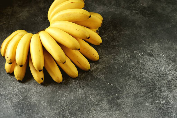 Baby bananas on a gray background. Copy space.  - Photo, Image