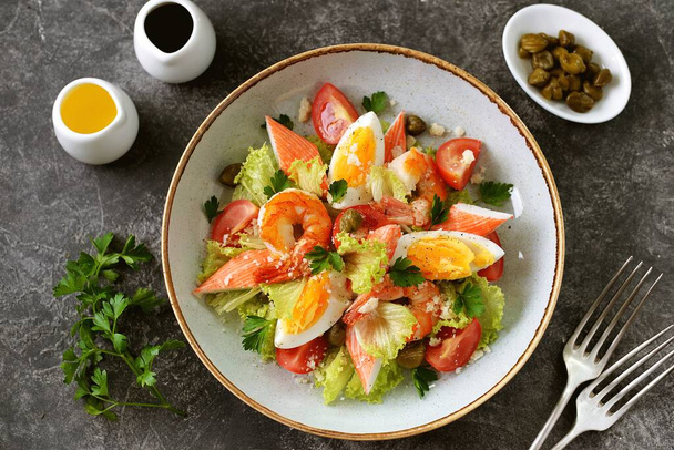 Салат с крабом, креветками, пармезаном, каперсами, помидорами черри и салатом. Здоровое питание
. - Фото, изображение