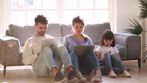 Mother father and little daughter sitting on floor with devices - Filmagem, Vídeo