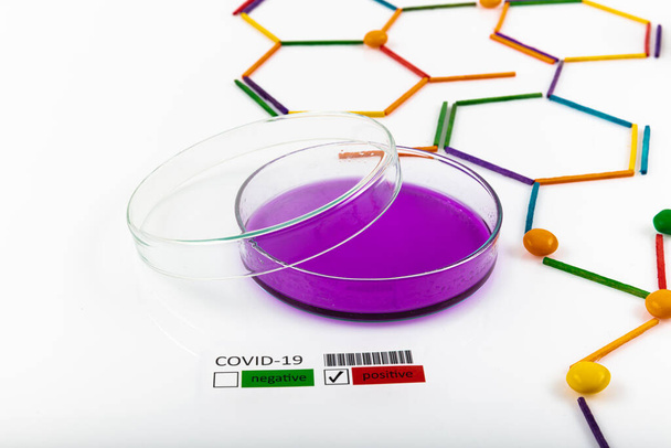 Konzept der Coronavirus-Epidemie. Inschrift COVID-19 gegen molekulares Chemie-Modell und Laborgeräte auf weißem Hintergrund. - Foto, Bild