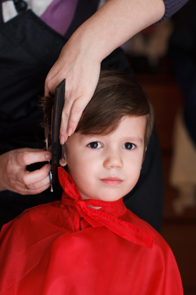 Niño pequeño con sonrisa en la peluquería con un corte de pelo
 - Foto, imagen