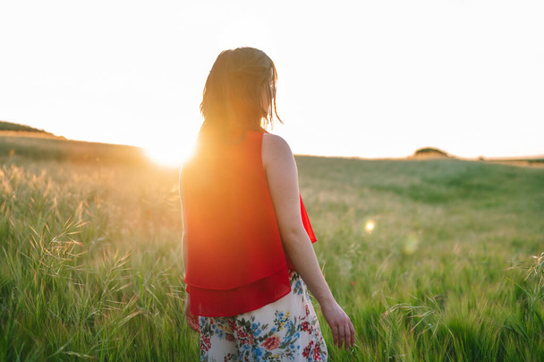 Muotokuva kaunis nuori nainen punainen mekko poseeraa ulkona auringonlaskun aikaan. - Valokuva, kuva