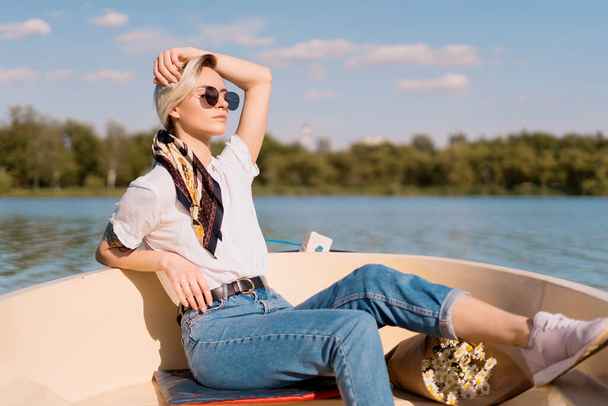 ボートの上でサングラスのファッショナブルな女性 - 写真・画像