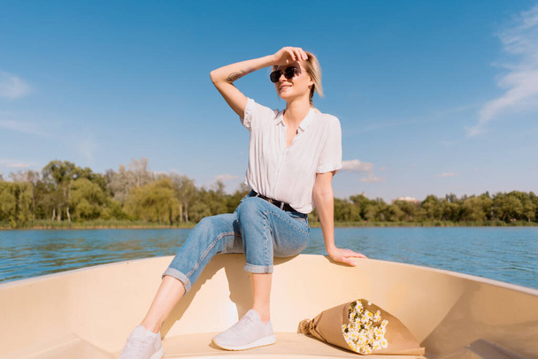 Donna alla moda in occhiali da sole sulla barca - Foto, immagini