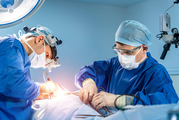 Operating room with surgery in progress. Medical team performing surgical operation in bright modern operating room - Foto, Imagem