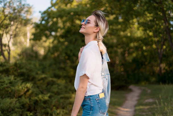Woman in sunglasses walking in the park - Photo, Image