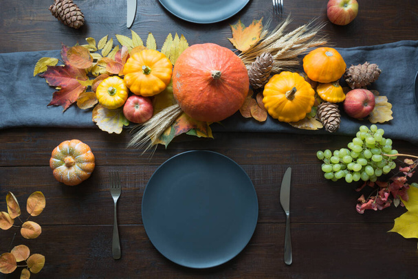 Fall dark place setting with leaves and pumpkins. Centerpieces Thanksgiving Day. Party. View from above. - Foto, imagen