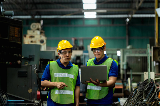 Μηχανικός και μηχανικός του προσωπικού μιλώντας κοντά σε μια μηχανή σε ένα μεγάλο εργοστάσιο για την τελευταία νέα planing, δύο άνδρες μηχανικός μιλώντας στο σύγχρονο εργοστάσιο. - Φωτογραφία, εικόνα