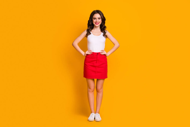 Full length photo of amazing lady arms by sides sunny summer day good mood go outdoors wear white casual singlet red mini skirt footwear isolated yellow color background - Valokuva, kuva