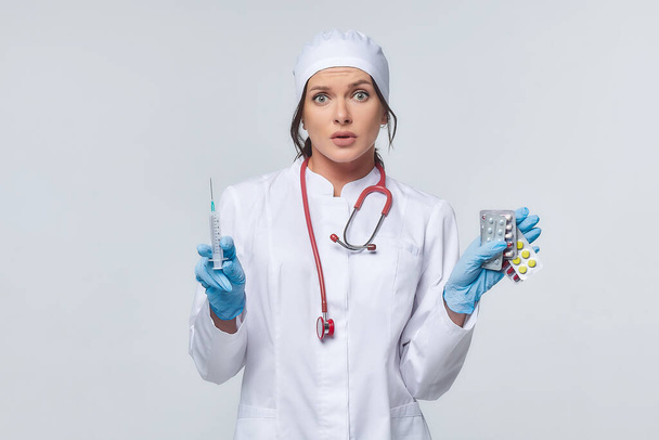 Medical concept of a female doctor in a white coat with a stethoscope, doctor. A female hospital worker looks at the camera and smiles, Studio, White background - Foto, immagini