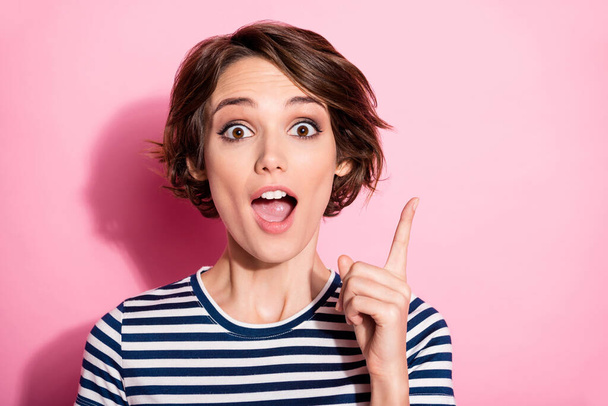 Closeup photo of crazy lady funny facial expression open mouth raise finger have amazing creative candid idea wear casual white blue t-shirt isolated pastel pink color background - 写真・画像