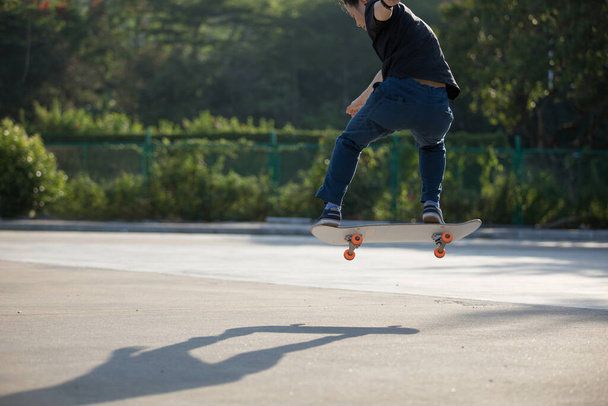 Skateboarder skateboarding at morning outdoors and doing tricks - Valokuva, kuva