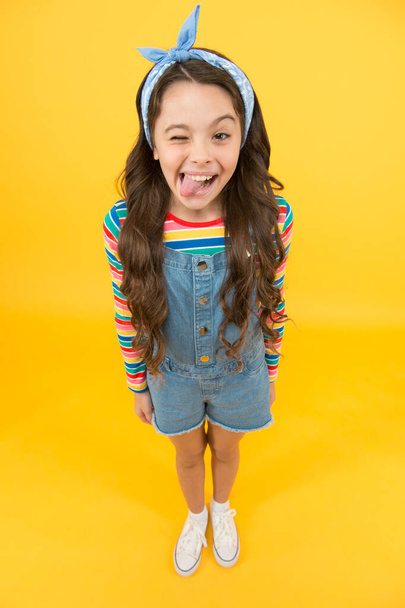 Beauty is whatever brings joy. Playful child grimace yellow background. Little girl in casual style. Beauty look of small fashion model. Beauty salon. Fashion and beauty. Children clothing - Foto, Imagem