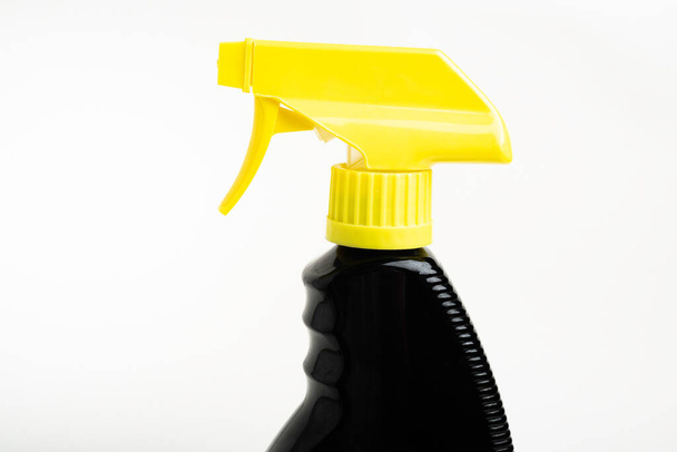 A close-up of the top portion of a black and yellow liquid spray plastic dispenser bottle set on a plain white background. - Фото, изображение