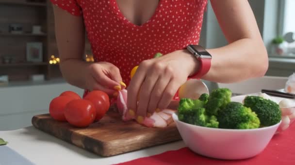 Mujer haciendo la ensalada con tocino en rodajas y verduras
 - Metraje, vídeo