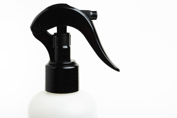 A close-up of the top portion of a black and white liquid spray plastic dispenser bottle set on a plain white background. - Foto, afbeelding