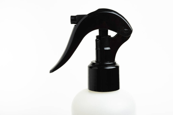 A close-up of the top portion of a black and white liquid spray plastic dispenser bottle set on a plain white background. - Photo, Image