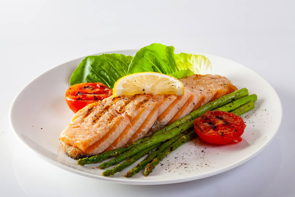 Roasted salmon steak with asparagos tomatoes  with fresh vegetable. - Photo, Image