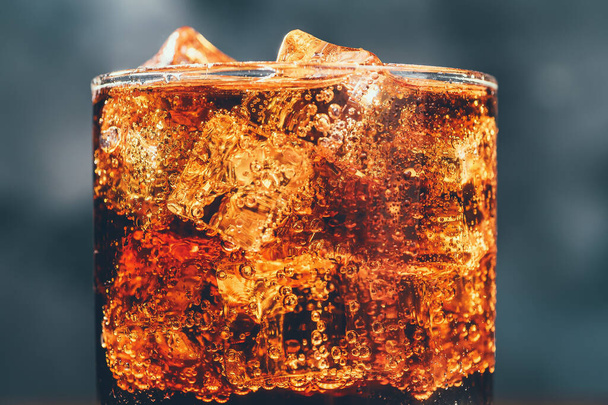 Cola soda drink in glass with ice cubes and bubbles, macro photo - Фото, изображение