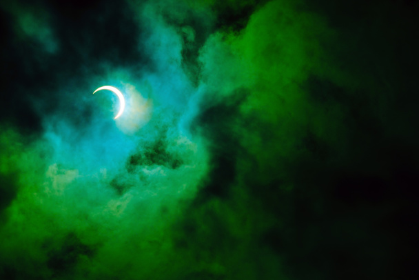 Eclipse solar anular parcial, conhecido em tais circunstâncias como um anel de fogo, visto na Malásia em 26 de dezembro de 2019. Tempo nublado no Kuala Lumpur obscurecendo grande parte da vista. Cor dramática aplicada
. - Foto, Imagem