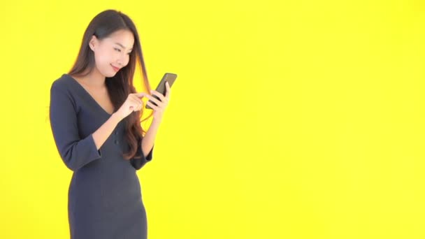 footage of beautiful asian businesswoman using smartphone on yellow - Imágenes, Vídeo