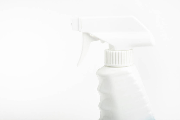 Düz beyaz arkaplan üzerine kurulmuş beyaz sıvı sprey plastik bir sprey şişenin üst kısmının yakın çekimi.. - Fotoğraf, Görsel
