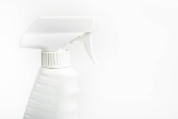 Eine Nahaufnahme des oberen Teils einer ganz weißen Sprühflasche aus Kunststoff auf einem schlichten weißen Hintergrund. - Foto, Bild