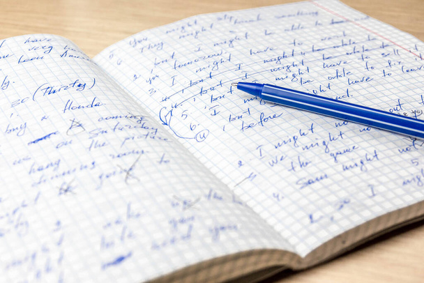 Hojas de cuaderno de estudiante de la escuela garabateadas con un bolígrafo azul
. - Foto, imagen
