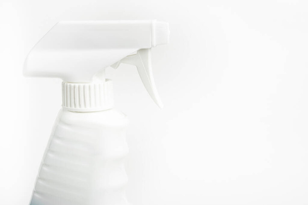 A close-up of the top portion of an all-white liquid spray plastic dispenser bottle set on a plain white background. - Zdjęcie, obraz