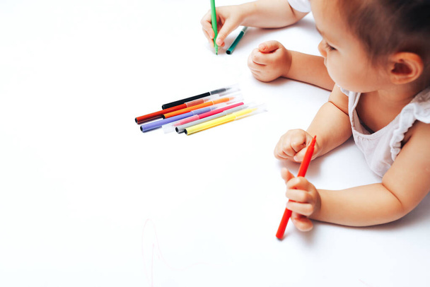 Talented children draw with colored felt-tip pens on white paper, lessons, tasks with children of the different ages. - Фото, зображення