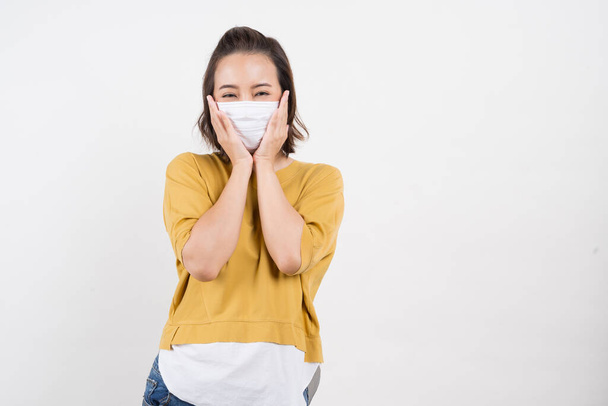 Giovane donna asiatica indossa maschera igienica per prevenire l'infezione virus corona Inquinamento atmosferico pm2.5 indossa un giallo T-shirt sparare in colpo isolato su sfondo bianco
 - Foto, immagini