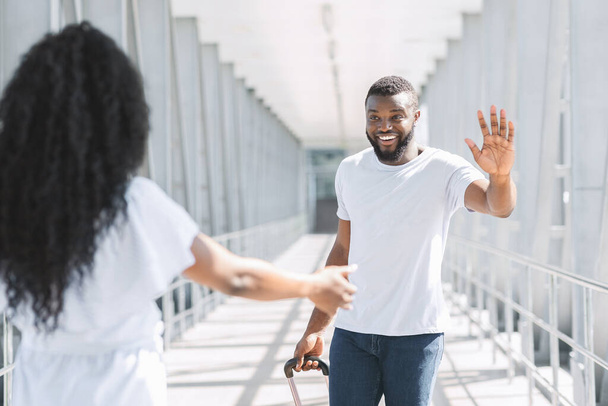 Happy Afro Man Χαιρετισμός φίλη του μετά την άφιξη στο αεροδρόμιο - Φωτογραφία, εικόνα
